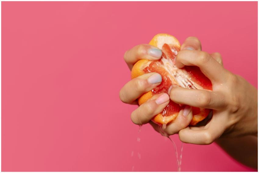 Close-up of hands squeezing juicy grapefruit again