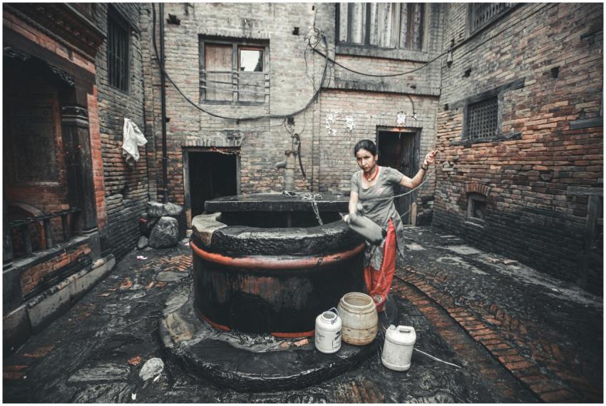 Traditional setting with woman fetching water from