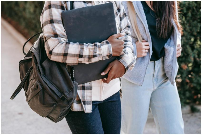 Unrecognizable young women carrying backpacks and