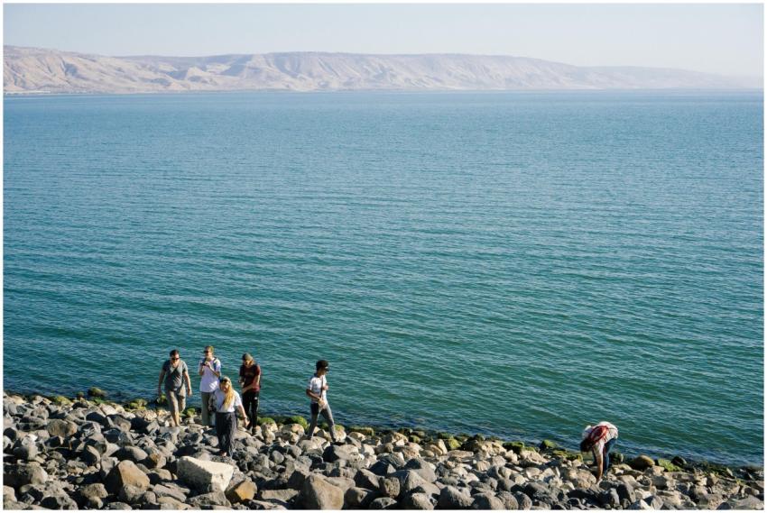 A group of adults leisurely walking on the rocky s
