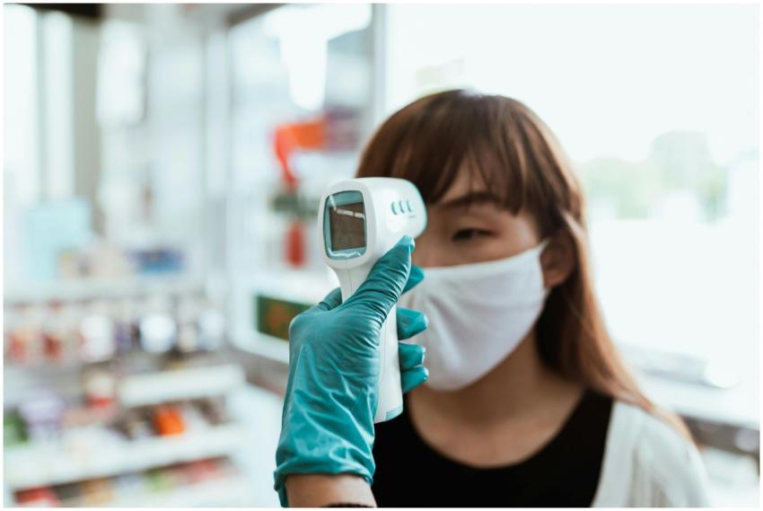 A woman in a face mask receives a contactless temp
