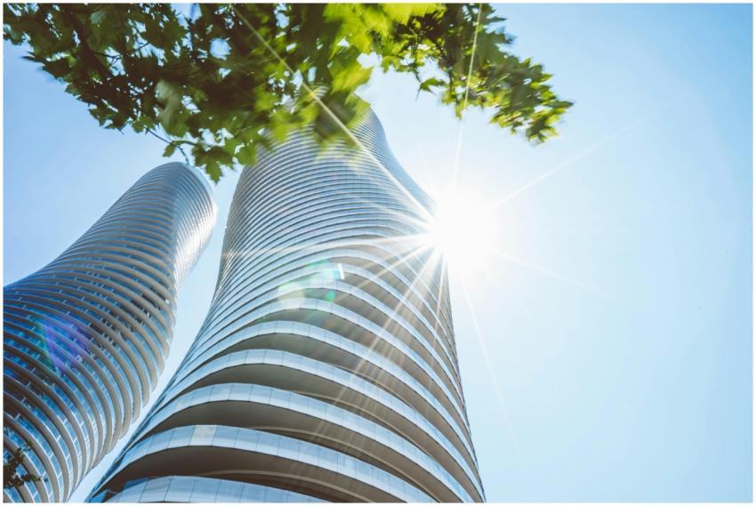 Modern skyscrapers with sun flare under a clear bl