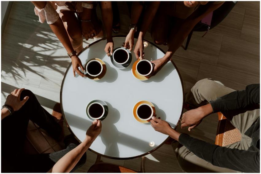A group of friends enjoying coffee around a café t