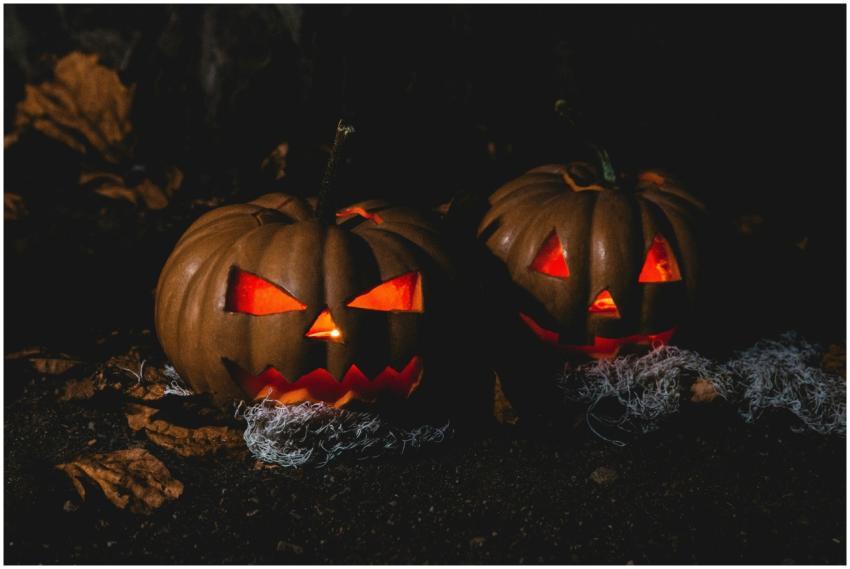 Two eerie jack-o'-lanterns with glowing eyes and s