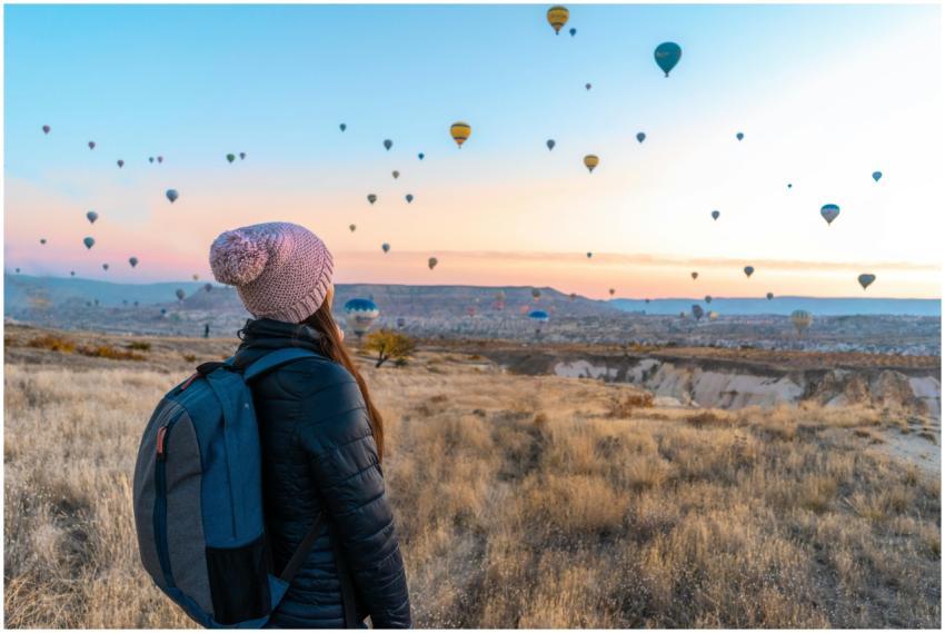 Woman watching hot air balloons in Cappadocia at s