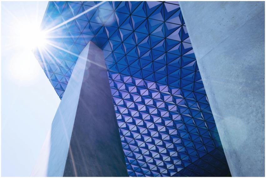 A modern skyscraper with a geometric facade and su