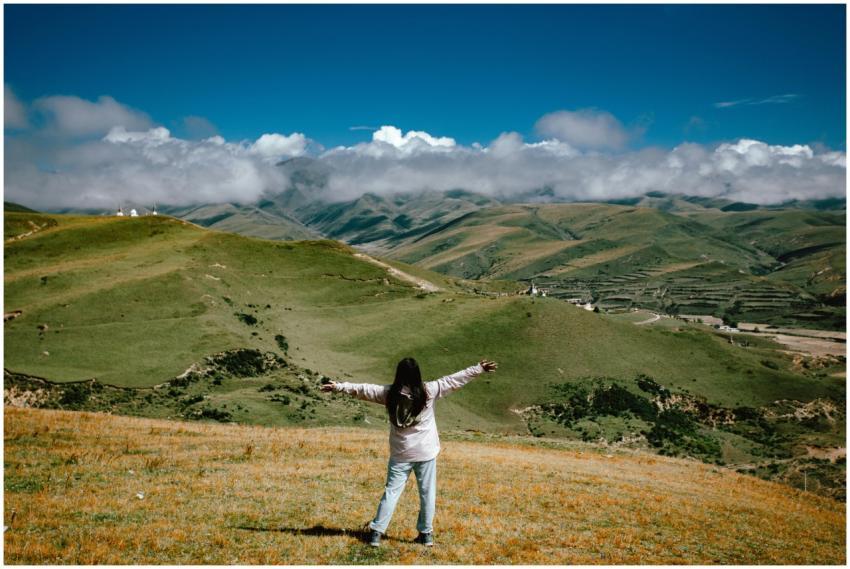 Woman with open arms enjoys a sweeping view of gre