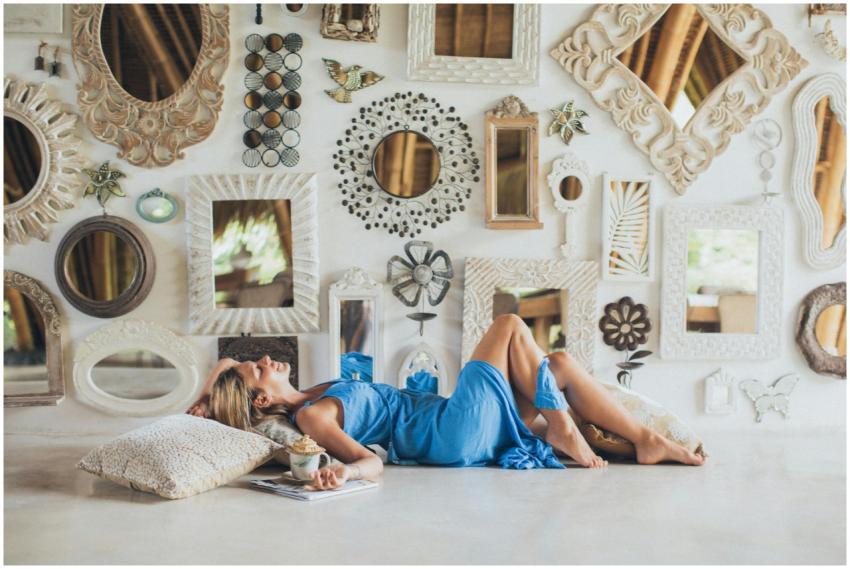 An adult woman in a blue dress relaxes indoors amo
