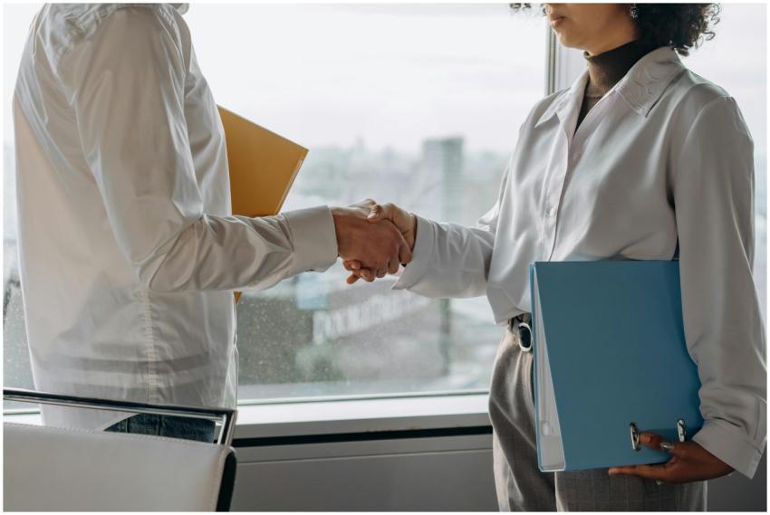 Two professionals in business attire shaking hands