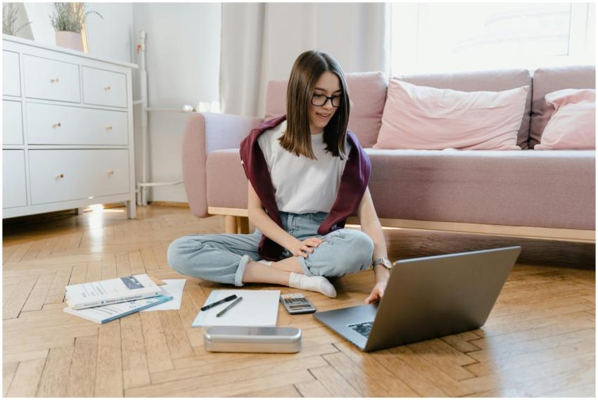 Teen girl studying online at home, sitting on the