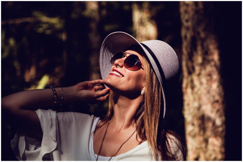 A fashionable woman in sunglasses and hat enjoying