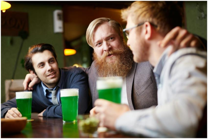 Three friends celebrating together with green beer