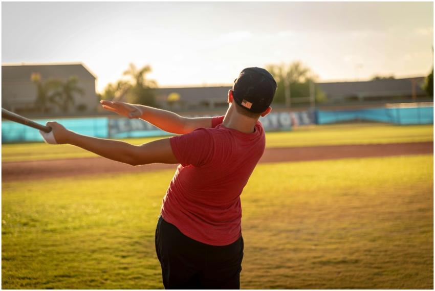 A young boy in a red shirt swings a baseball bat o