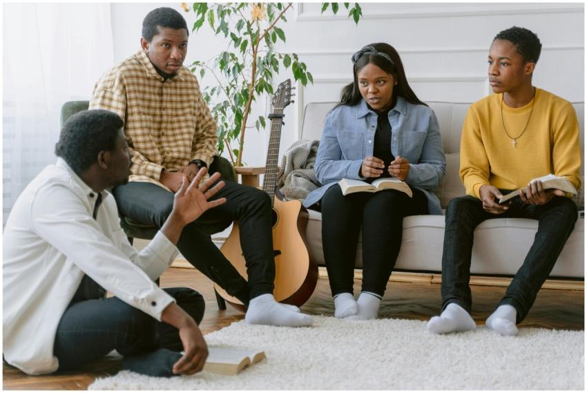 A group of four adults engaging in prayer and musi
