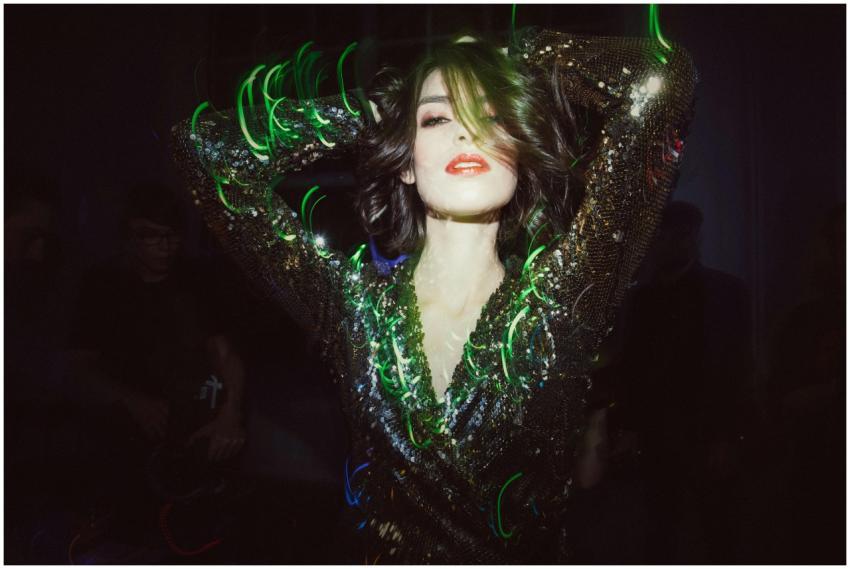 Stylish woman dancing in a sparkling dress with vi