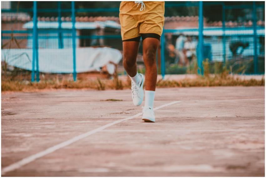 Close-up of a man's legs running on an outdoor bas