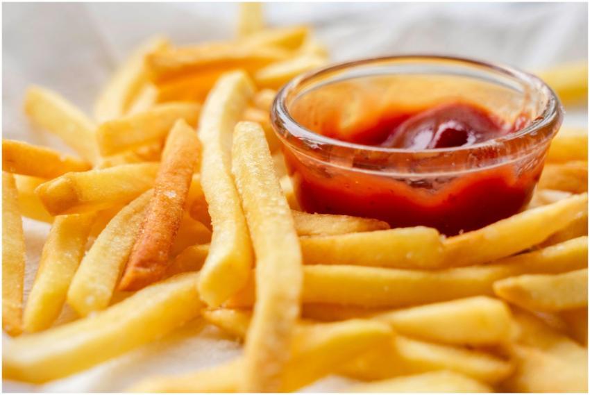 Close-up of crispy French fries served with a bowl
