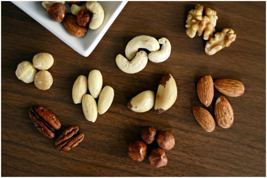 Close-up of various nuts on a wooden table, showca