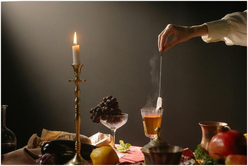 A classic still life portraying a hand dipping a t