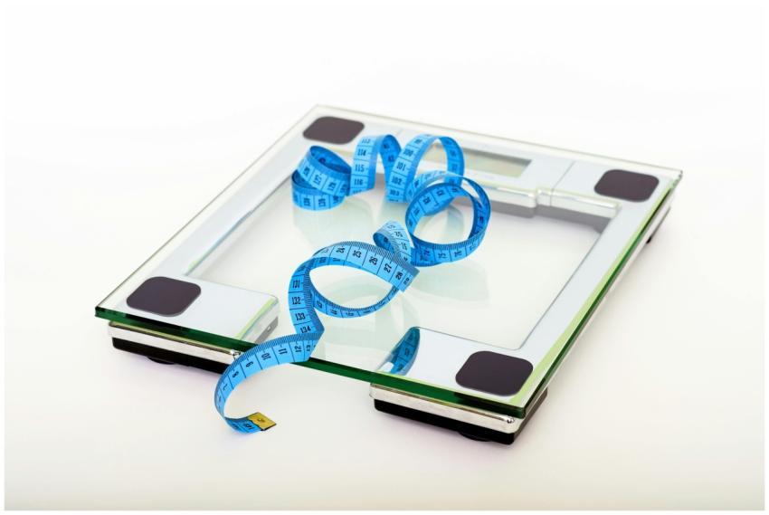 A digital glass weighing scale with a blue measuri