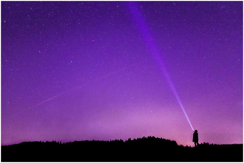 A person with a flashlight standing under a vibran