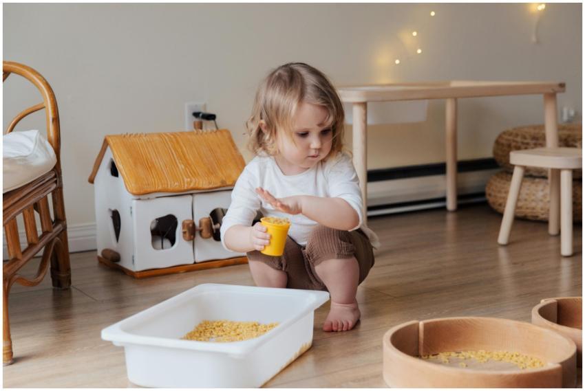 A young child playing with macaroni in a cozy indo