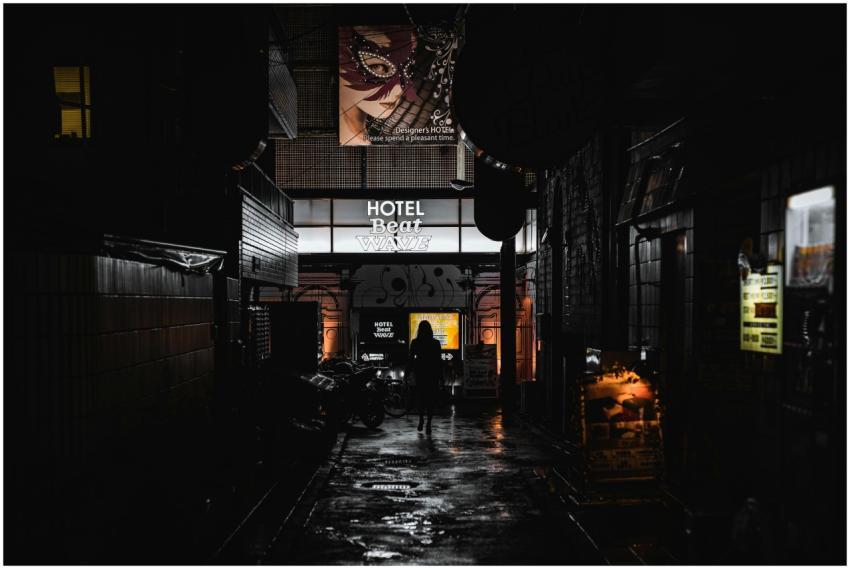 Silhouette of a woman walking down a dimly lit all