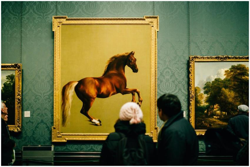 Visitors view a majestic horse painting at a museu