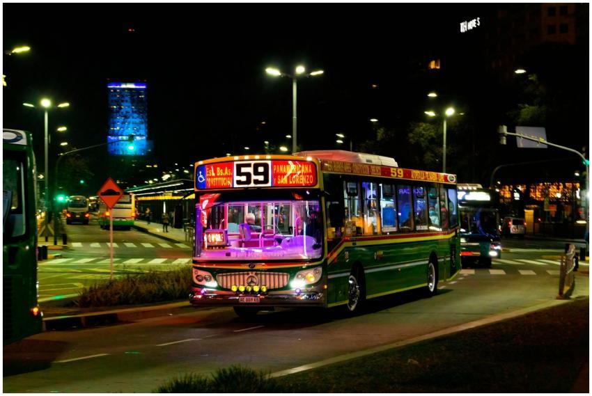 Brightly lit bus on Buenos Aires city street at ni