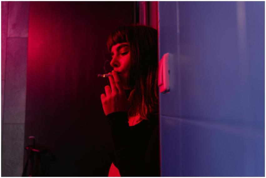 Moody indoor photo of a woman smoking in a nightcl
