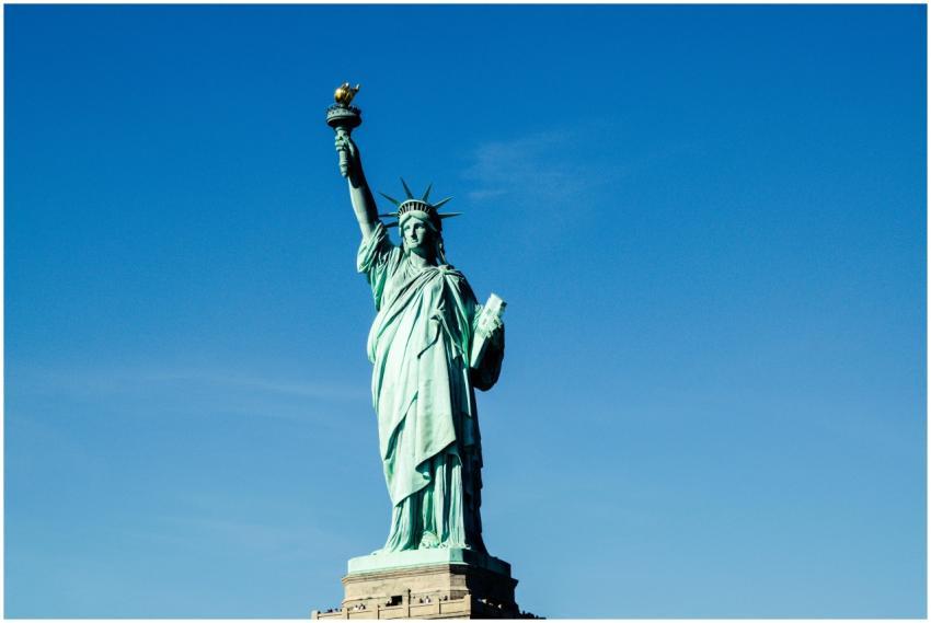 Iconic Statue of Liberty with vibrant blue sky bac