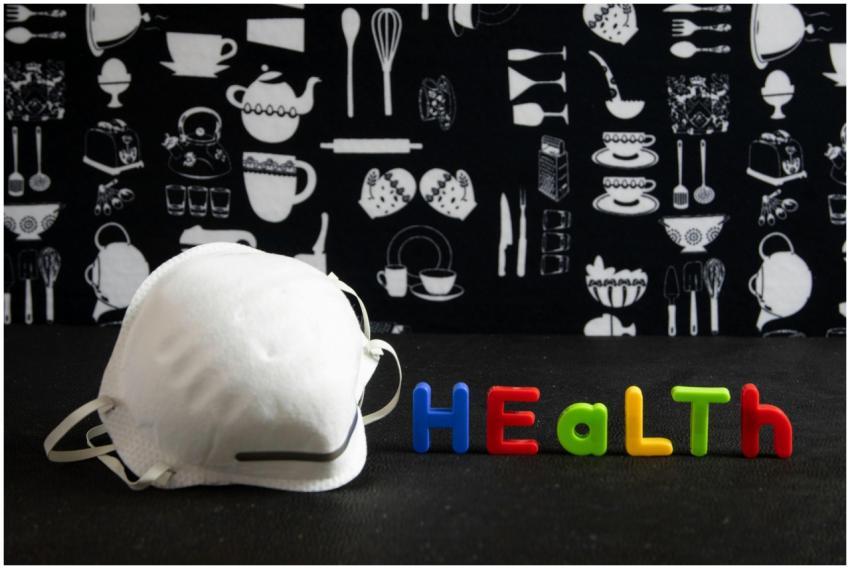 A face mask and colorful health text on a kitchen-
