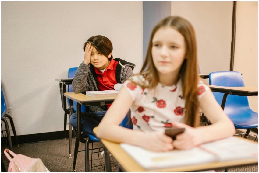 Two students in a classroom setting, focused on th