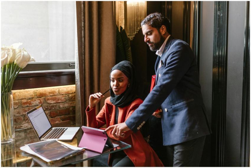 Two professionals discussing a project using a tab