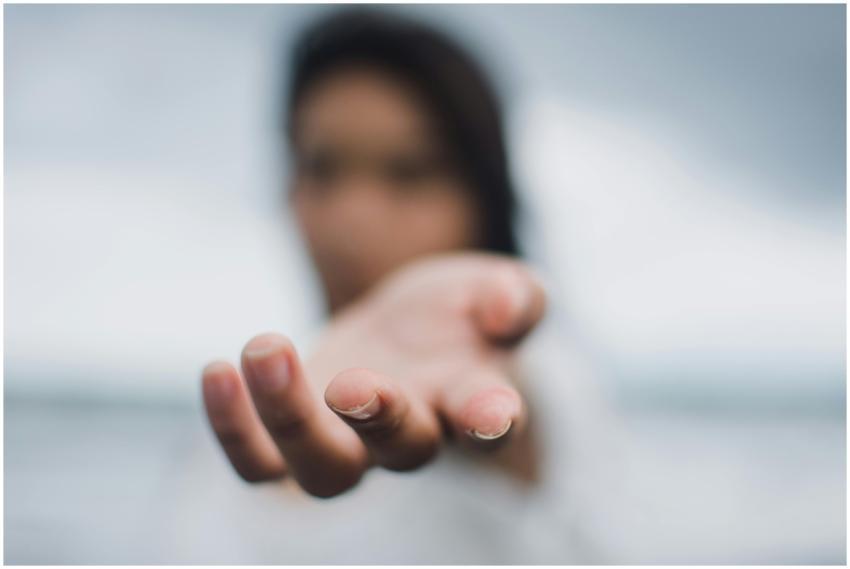 A soft focus image highlighting a reaching hand, s