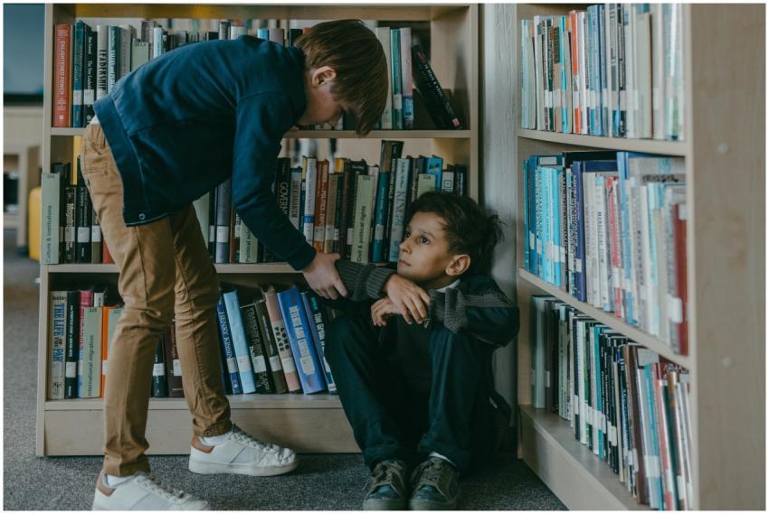 A concerned boy interacting with a classmate sitti