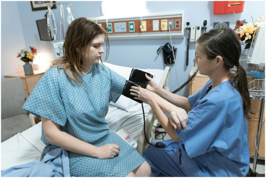 A nurse measures a patient's blood pressure in a h