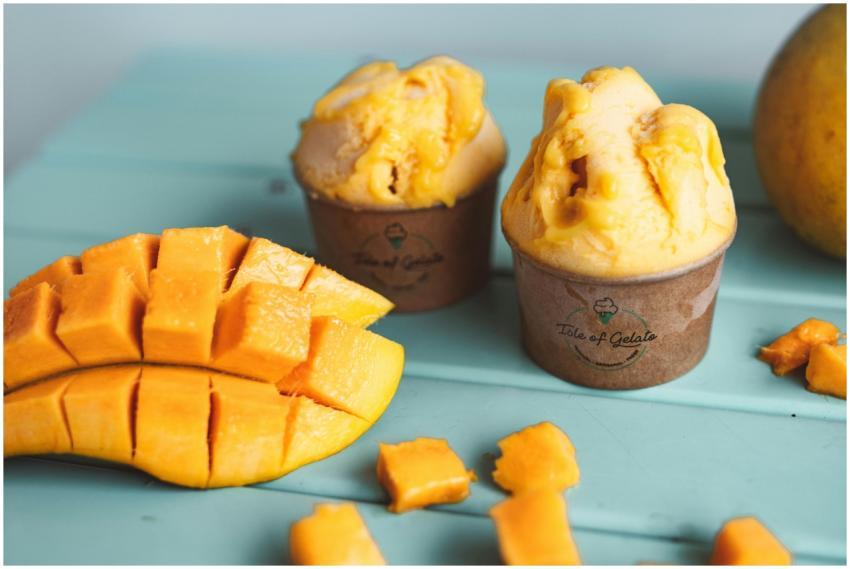 Mango gelato scoops in cups with fresh mango slice