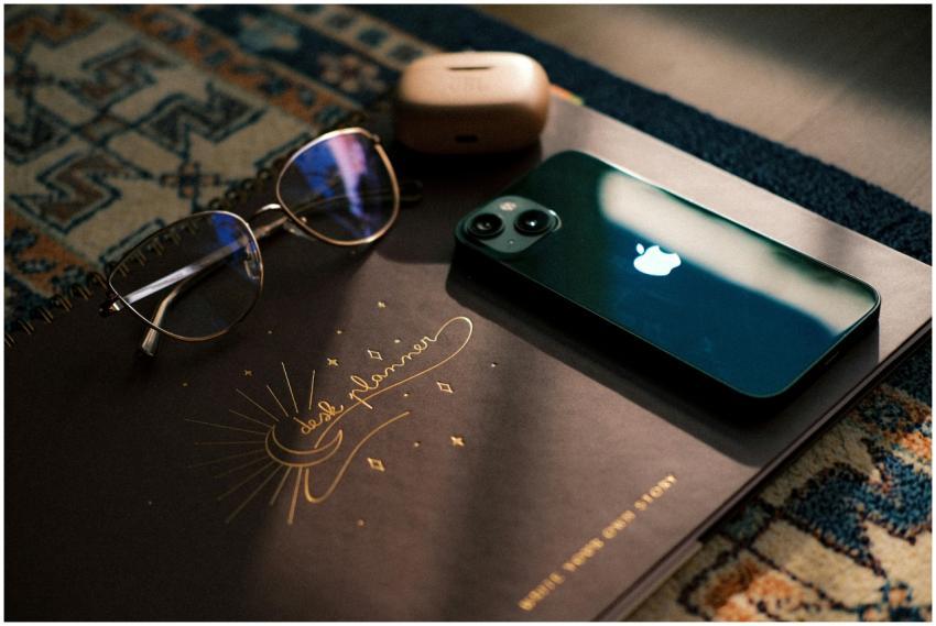 Stylish desk setup featuring notebook, sunglasses,