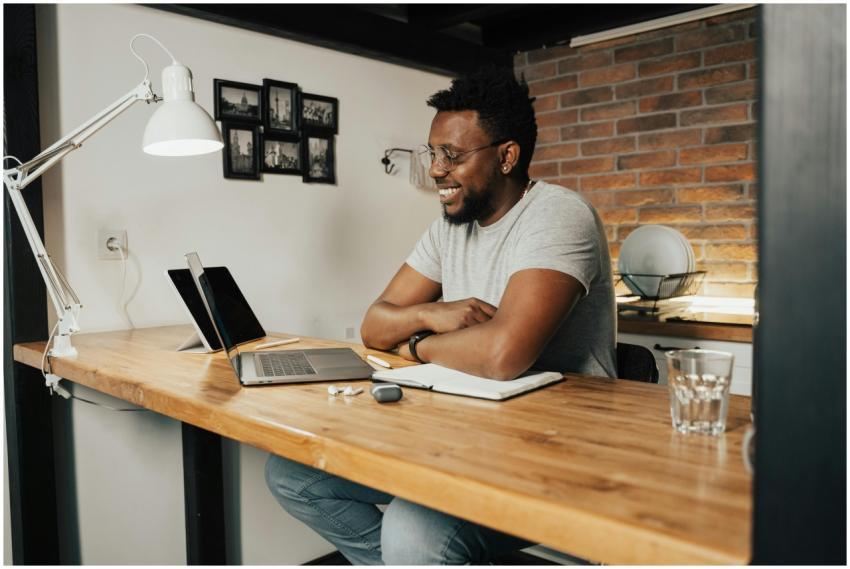 African American man smiling and working remotely