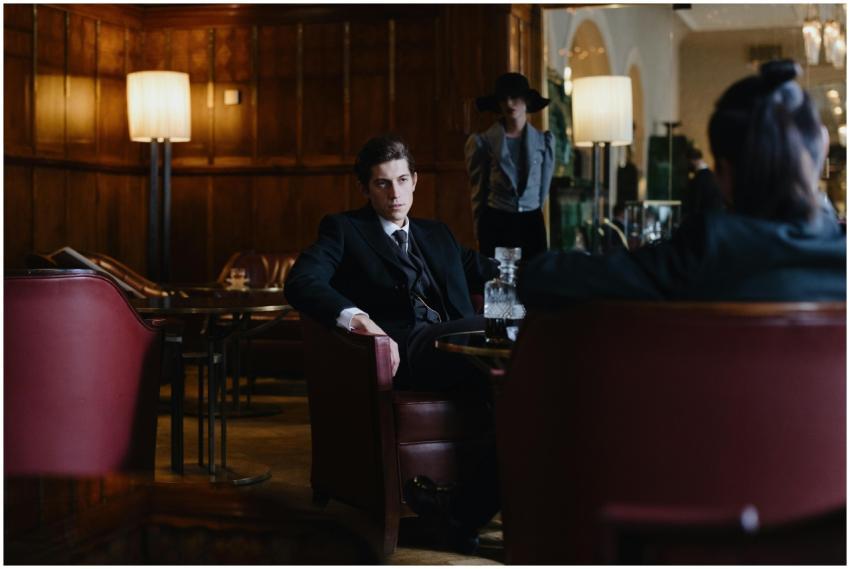 A man in a suit sitting in an elegant lounge with