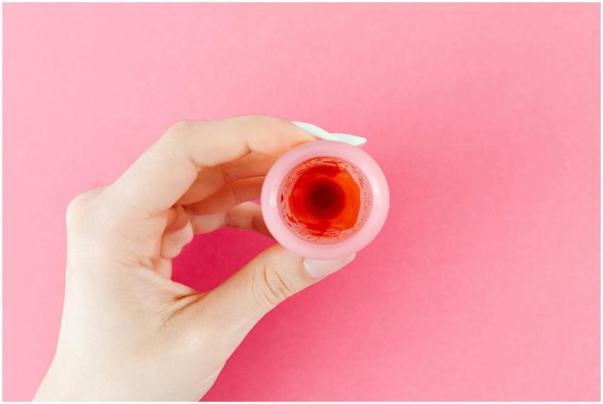 A detailed view of a menstrual cup with red liquid