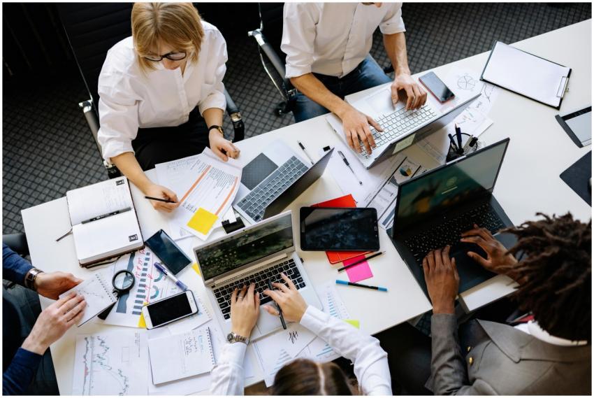 Vibrant office teamwork scene with laptops, docume