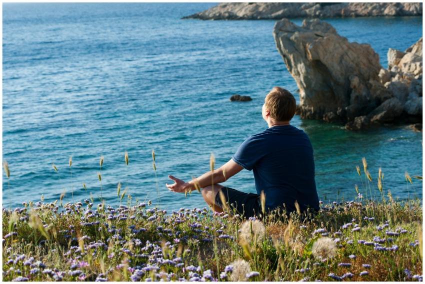 A man enjoys a peaceful moment surrounded by flowe