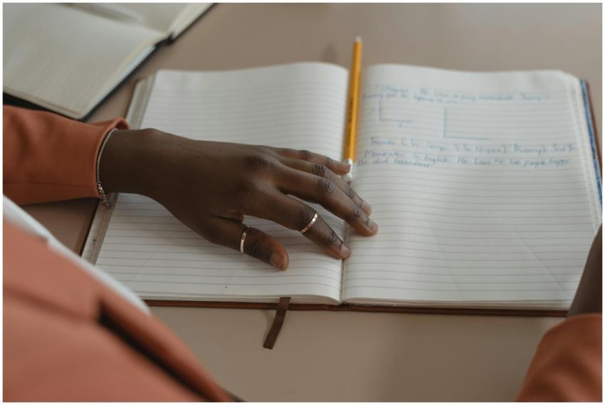 Close-up of a hand writing in a planner with styli