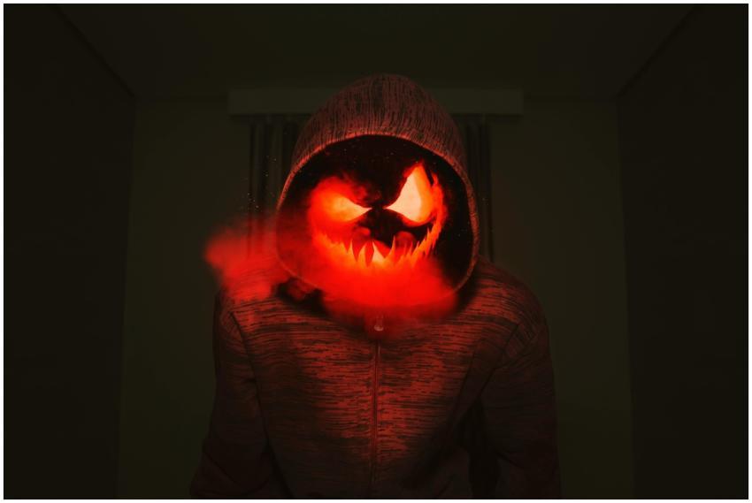 A spooky pumpkin head in a hoodie exudes a creepy