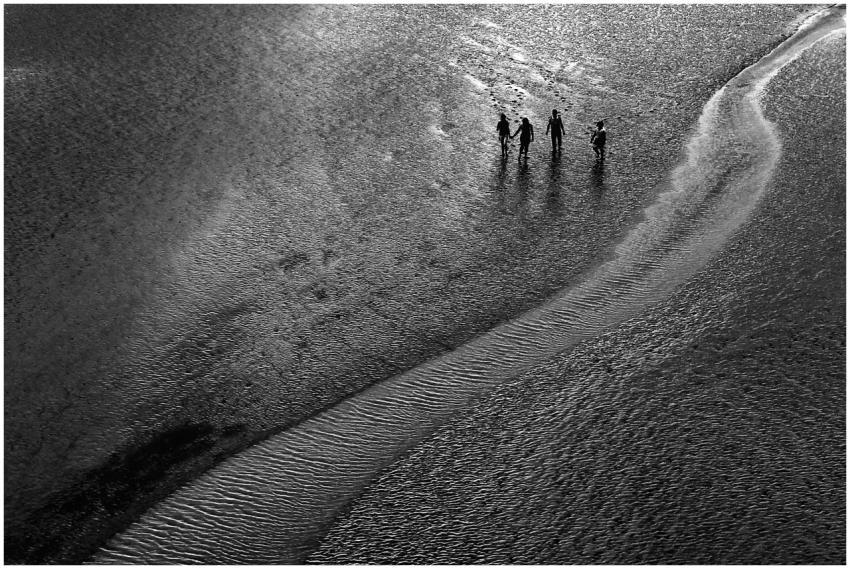 Monochrome aerial view of people walking along a b