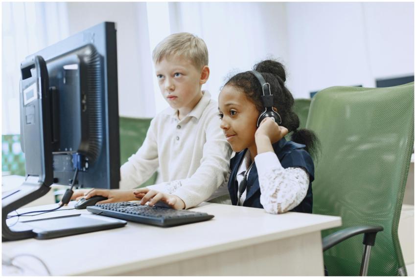Two children in a computer lab using a desktop com