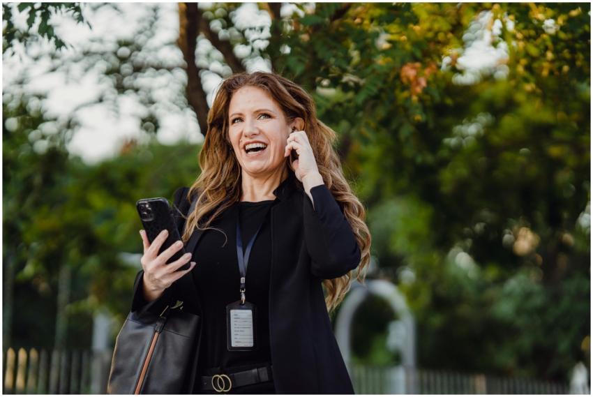 Smiling woman in a park making a phone call with c
