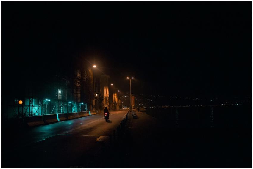Street scene at night with a lone motorcycle under